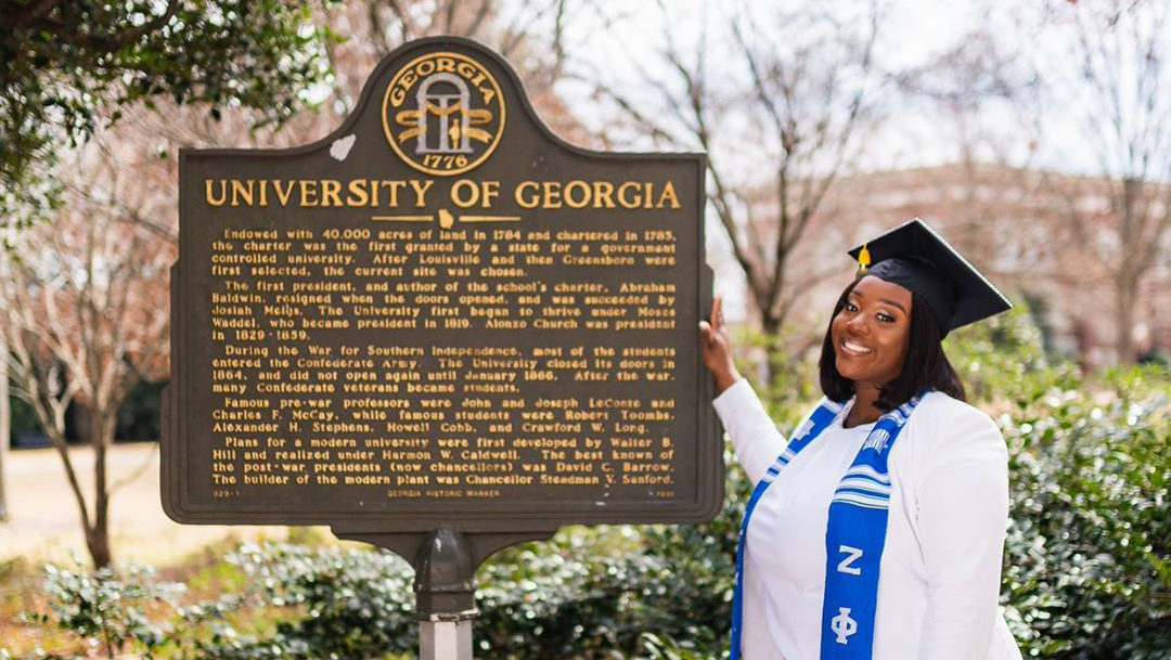 Achieve Atlanta student beside UGA sign