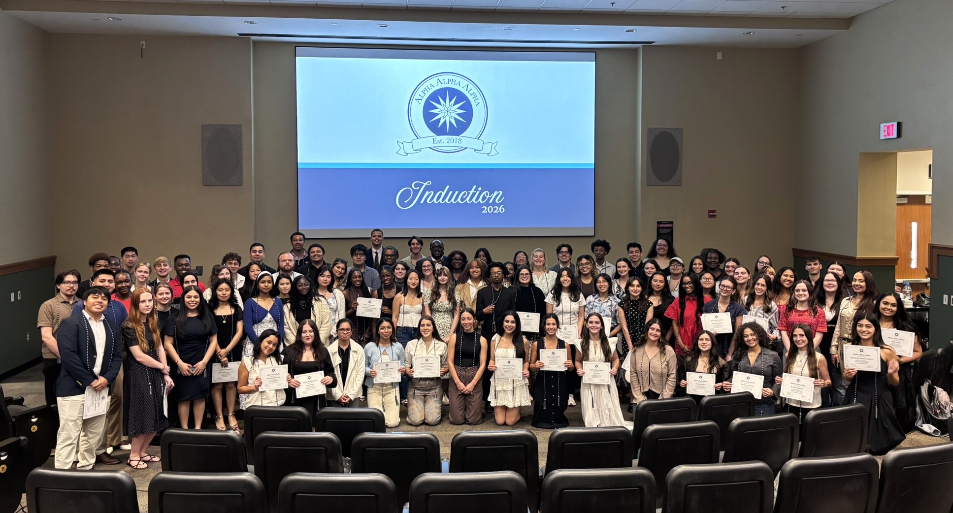 A large group of students pose for a photo during the Alpha Alpha Alpha induction ceremony on April 6, 2026