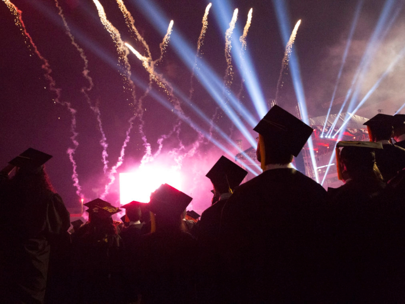 Students watch fireworks at the conclusion of a commencement ceremony.