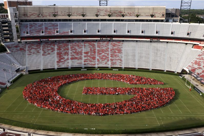 The class of 2029 poses in the outline of the Georgia "G" on the field at Sanford Stadium.