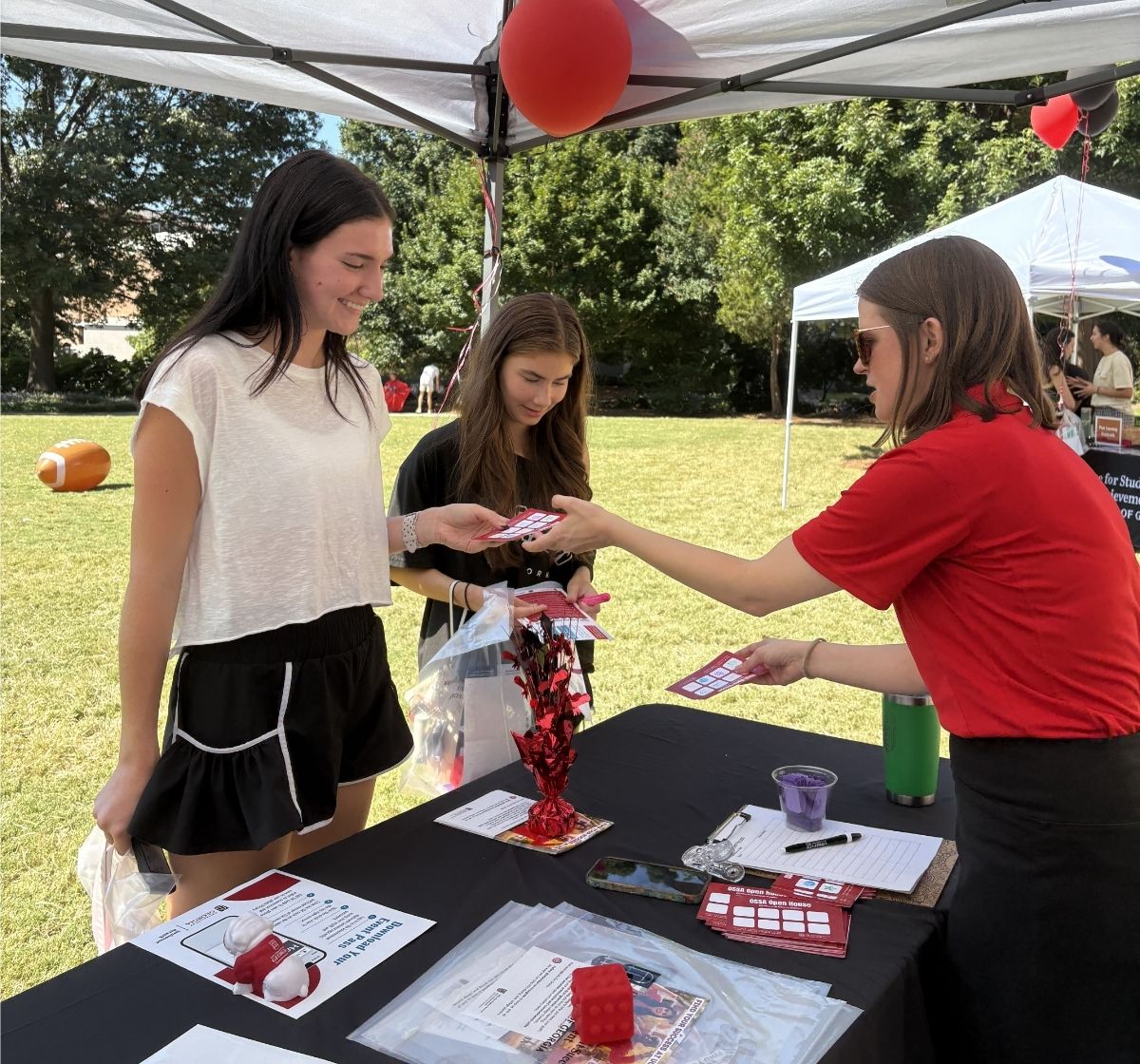 Two UGA students interacting with an OSSA staff member at the 2025 Milledge Hall Open House