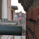 Side of the Miller Learning Center with American and UGA flags in the wind.