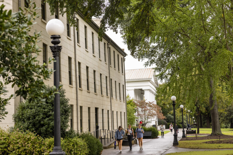 Students walk past the New College building on UGA's campus in late summer.