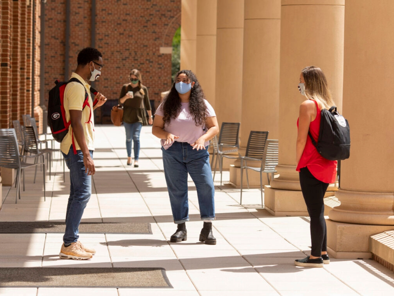 Undergraduates socialize on the balcony of Amos Hall at the Terry Business Learning Community.